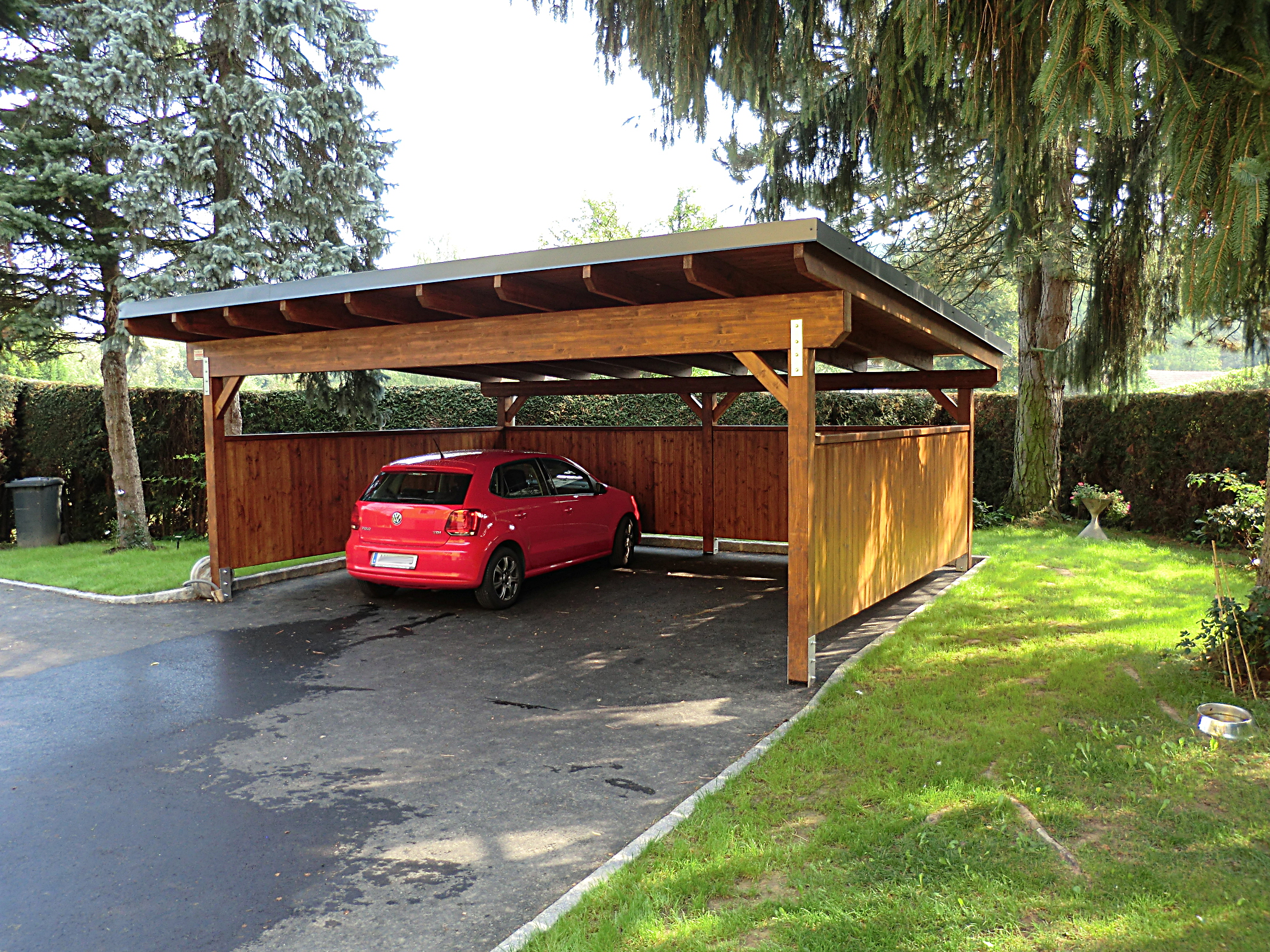 Freistehender Holzcarport mit Flachdach und seitlicher Holzverkleidung im Mostviertel